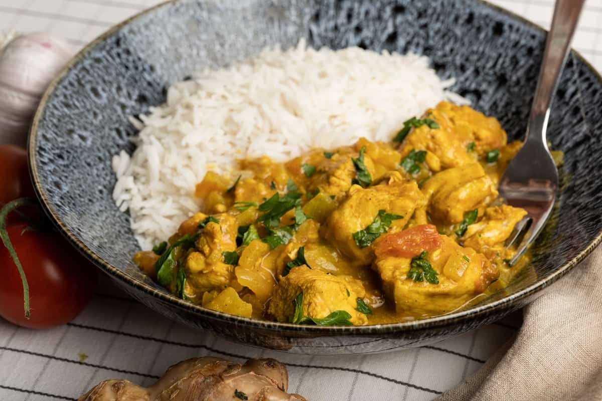 close up of boneless mango chicken curry recipe with a side of basmati rice