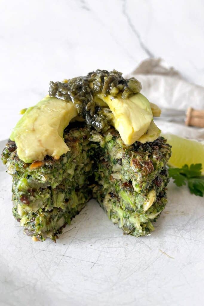 vegan broccoli fritters cut in the middle with avocado and seaweed on top