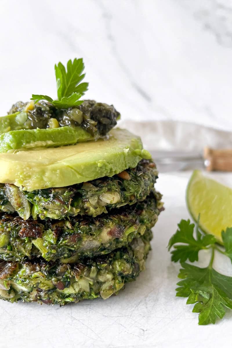 vegan broccoli fritters stacked with avocado