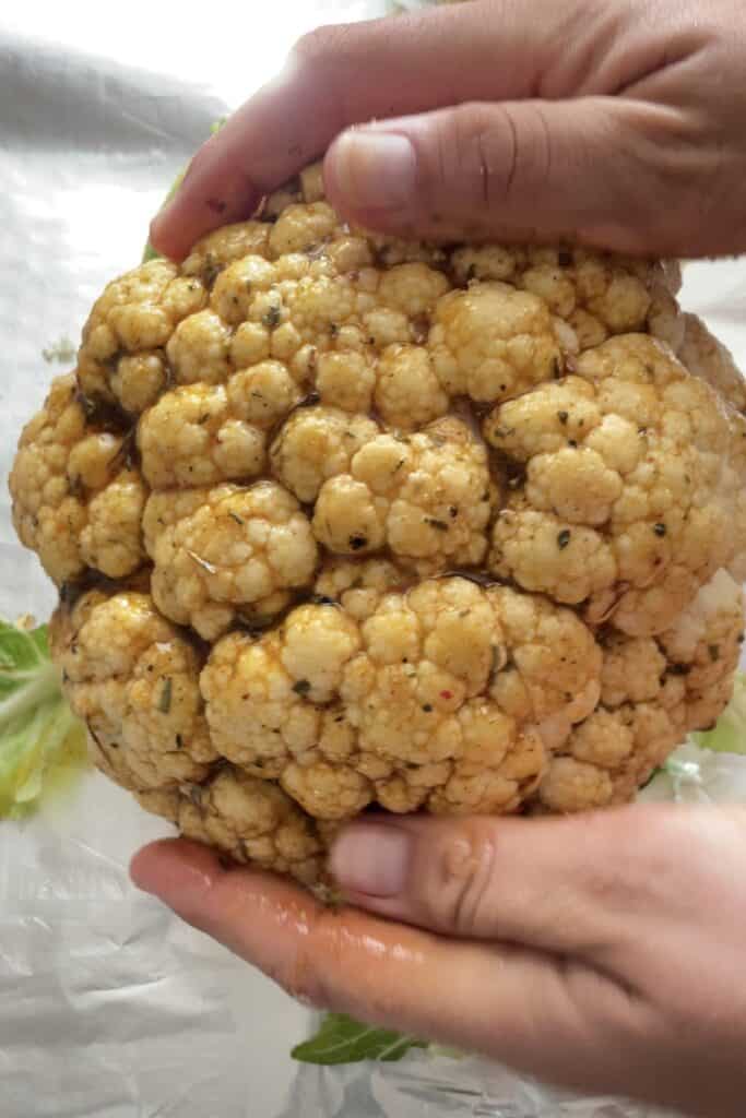 Spread the mix throughout the entire cauliflower with the hands