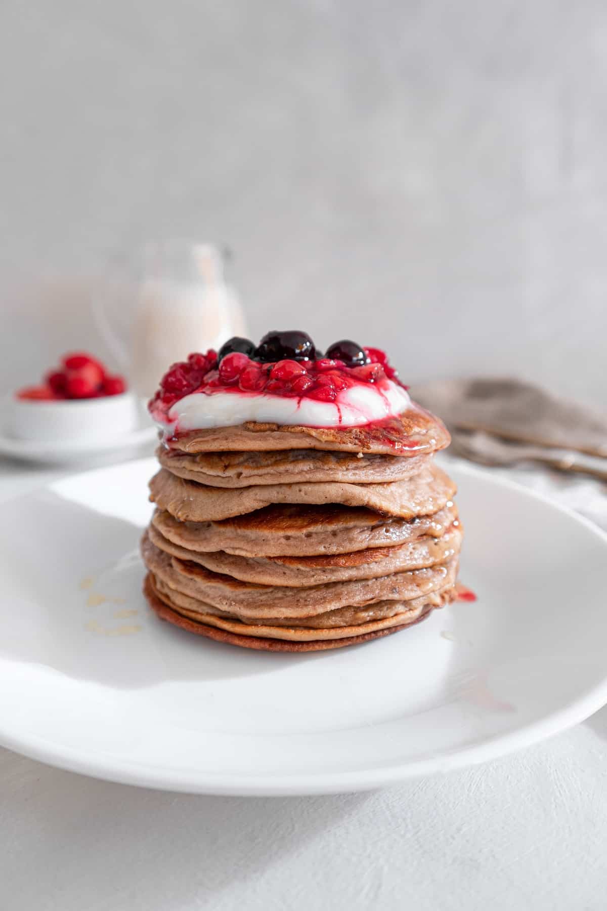 Chestnut flour pancakes with coconut yogurt and berries on top