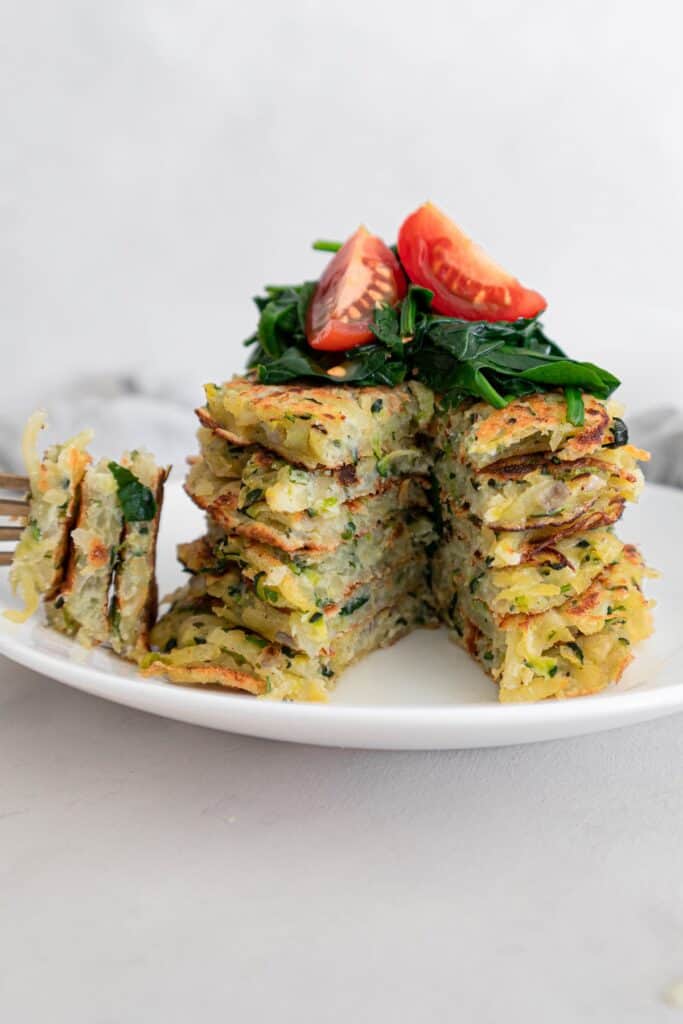 Stack of zucchini and potato fritters (Gluten-free) with a cut in the middle