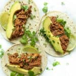 Pulled BBQ beef brisket tacos with avocado slices