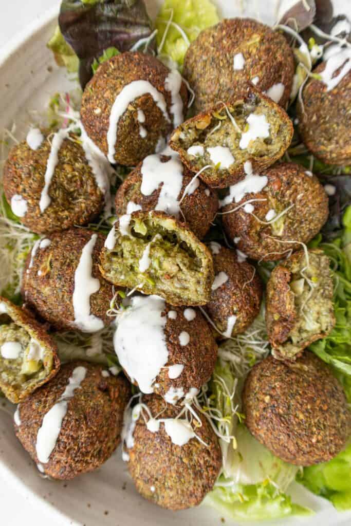 Vegan broccoli falafel on a bowl with a drizzle of tahini sauce