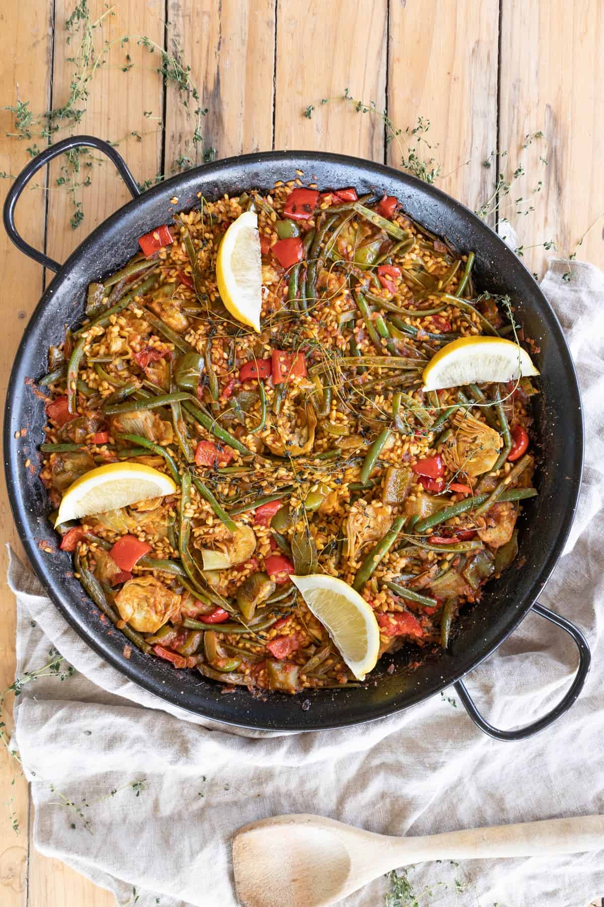 Authentic vegetable paella with lemon wedges
