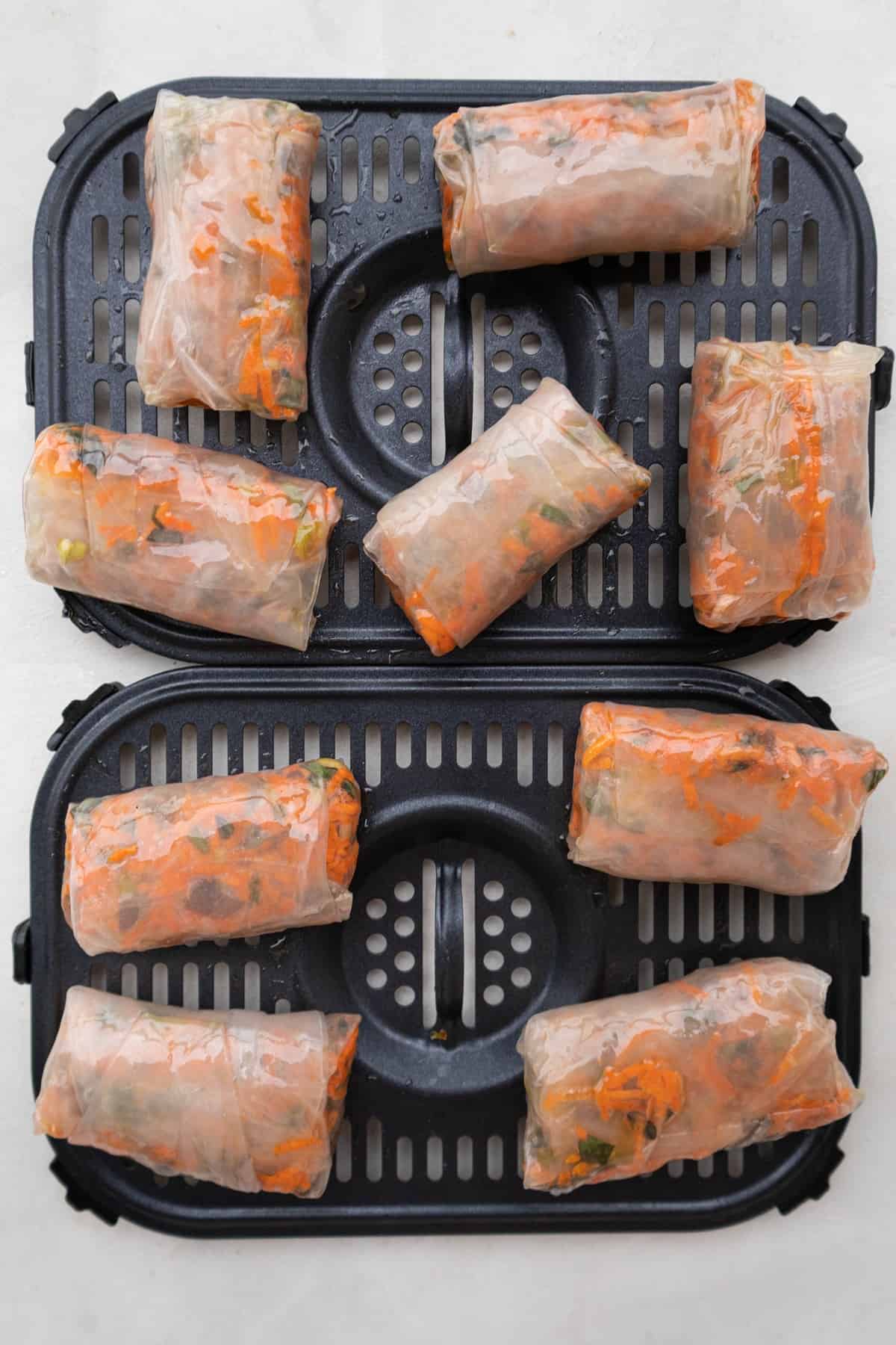 Rice paper rolls brushed with olive oil on air fryer tray