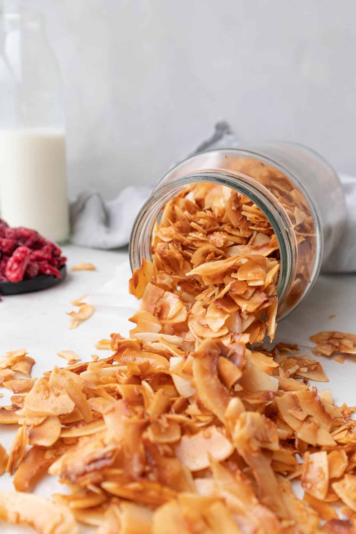 Toasted sweetened coconut flakes coming out of a jar