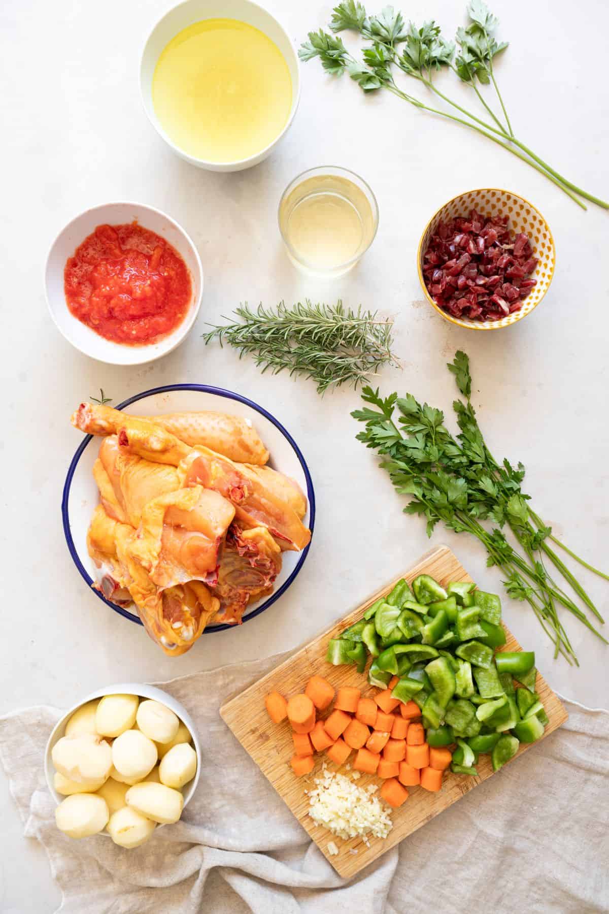 Raw Spanish chicken stew ingredients on bench
